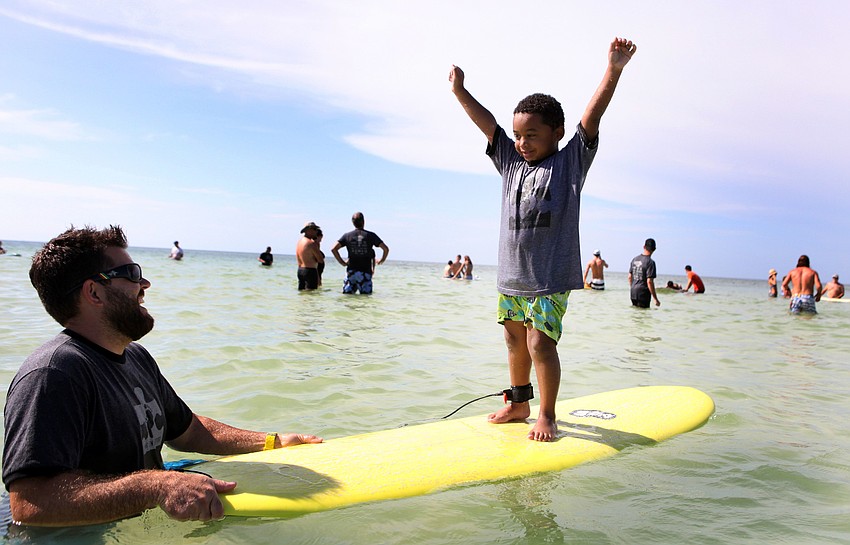 Mark Weeks laughs as Caiden Woodworth, 5, raises his arms up in the air victoriously Saturday, Sept. 15 during Hang 10 for Autism at Siesta Key Public Beach.