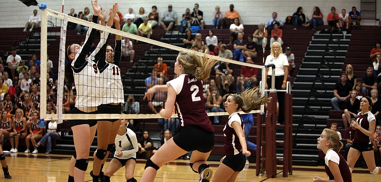Emily Harding, No. 9, and Jacky Mogensen, No. 11, attempt to block Jen Moorâ€™s, No. 2, spike over the net during the first of three games played Monday, Sept. 17 at Riverview High Schoolâ€™s Gymnasium.