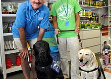 Jim Cliff and Laurie Ginsburg stand with ambassador dogs, Tiz and Squire.