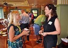 Debbie Lamb and Brenda Becker exchange business cards Wednesday, Sept. 26 at Sarasota Chamber of Commerceâ€™s Power Hour at Tommy Bahama.