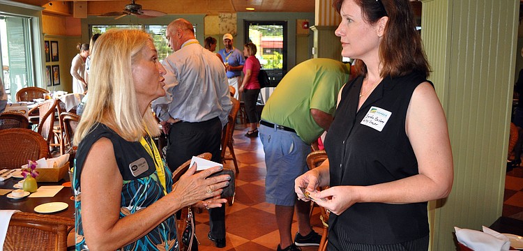 Debbie Lamb and Brenda Becker exchange business cards Wednesday, Sept. 26 at Sarasota Chamber of Commerceâ€™s Power Hour at Tommy Bahama.