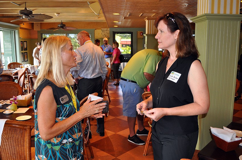 Debbie Lamb and Brenda Becker exchange business cards Wednesday, Sept. 26 at Sarasota Chamber of Commerceâ€™s Power Hour at Tommy Bahama.