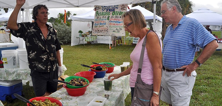 Mark Webster of The Happy Pickle sells Cindy and Art Hillman some half sour pickles, Wednesday, Oct. 3, the opening day of the Phillippi Farmhouse Market.