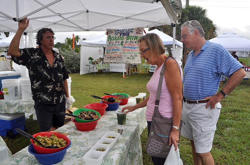 Mark Webster of The Happy Pickle sells Cindy and Art Hillman some half sour pickles, Wednesday, Oct. 3, the opening day of the Phillippi Farmhouse Market.