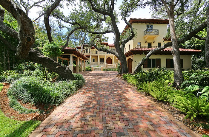 The two-story waterfront home features authentic clay tile roof and wood columns throughout the interior, and 100 feet of bay front views.