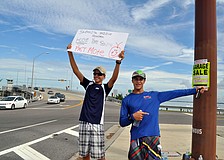 Zack Jordan, 15, and Luca Galarza, 15, held up signs and pointed the way to the garage sale Saturday, Oct. 6.