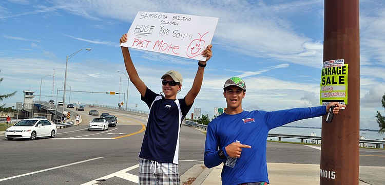 Zack Jordan, 15, and Luca Galarza, 15, held up signs and pointed the way to the garage sale Saturday, Oct. 6.