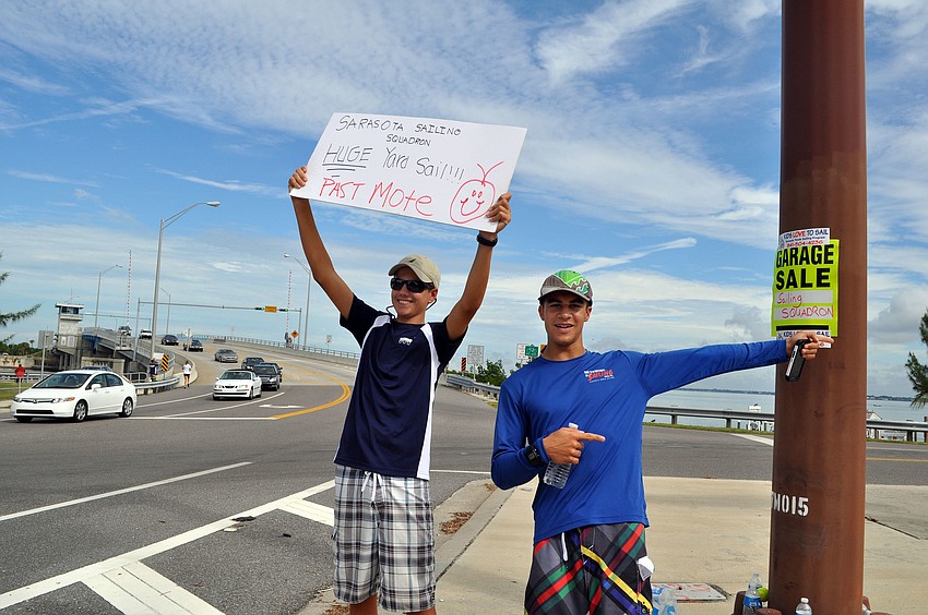 Zack Jordan, 15, and Luca Galarza, 15, held up signs and pointed the way to the garage sale Saturday, Oct. 6.