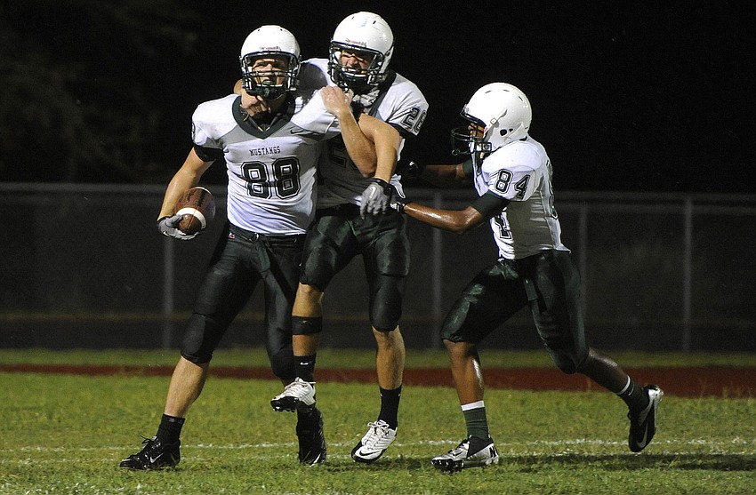 Wide receivers Wyatt McLeod and Cameron Pearcey congratulate Ty McLeod, No. 88, following his 29-yard touchdown run in the second quarter.