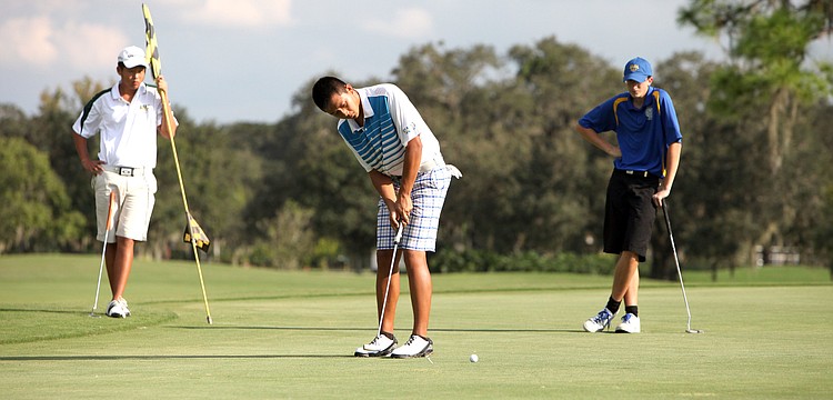 Ken Shi, 17, of Sarasota Christian, putts while David Gao, 13, of St. Stephenâ€™s, and Stephen Waskom, 16, of Sarasota Military Academy, look on Tuesday, Oct. 9, at the Bent Tree Country Club.