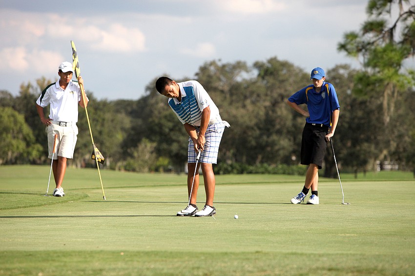 Ken Shi, 17, of Sarasota Christian, putts while David Gao, 13, of St. Stephenâ€™s, and Stephen Waskom, 16, of Sarasota Military Academy, look on Tuesday, Oct. 9, at the Bent Tree Country Club.
