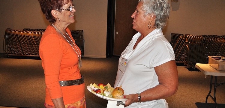 Kathy Roche and Karen Martin chit-chat with one another Monday, Oct. 8, during the welcome back luncheon for the Womenâ€™s Guild at St. Michael the Archangel.