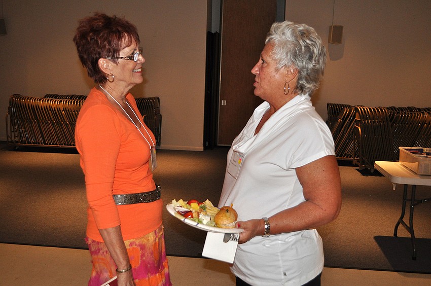 Kathy Roche and Karen Martin chit-chat with one another Monday, Oct. 8, during the welcome back luncheon for the Womenâ€™s Guild at St. Michael the Archangel.