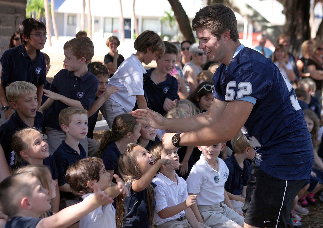 Max Provost high-fives the lower school students during the pep rally, Thursday, Oct. 18.