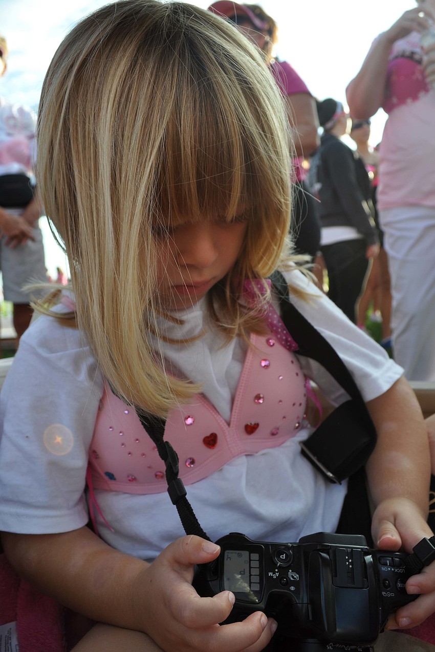 Madison Brenton, 3, played with her momâ€™s camera as the walk got started.