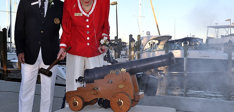 Ray Hutchins helps Jean Hendry as she fires the cannon during the Change of Watch ceremony Saturday, Oct. 20, at the Sarasota Yacht Club.