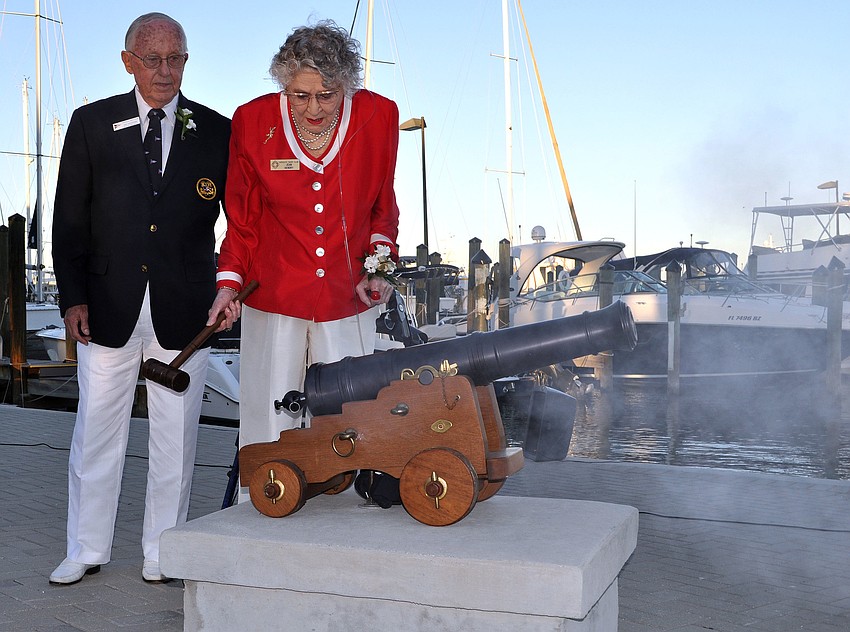 Ray Hutchins helps Jean Hendry as she fires the cannon during the Change of Watch ceremony Saturday, Oct. 20, at the Sarasota Yacht Club.