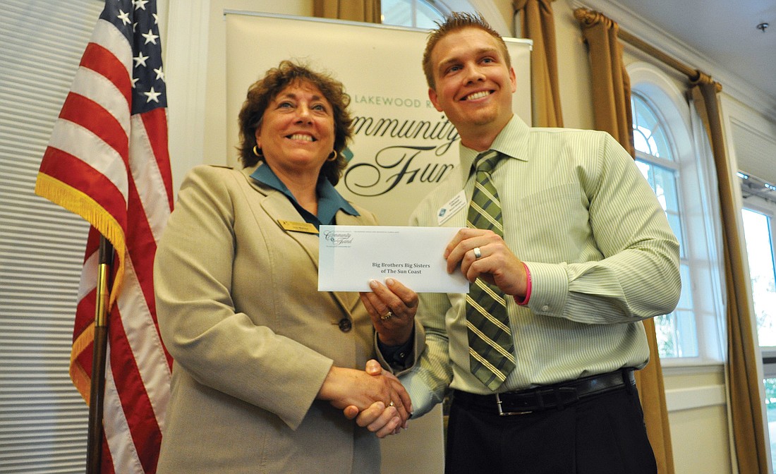 Joy Mahler, CEO for Big Brothers Big Sisters of the Sun Coast, accepts a check from Lakewood Ranch Community Fund Board Member Garrett Shinn, during a ceremony Oct. 19.