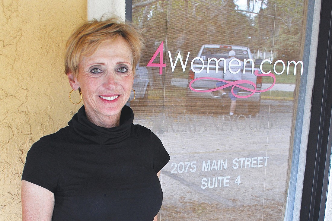 Susan Beausang stands outside her 4women.com office on Main Street, which, along with five other businesses, was recently damaged in an act of arson. Photos by Rachel S. O'Hara.