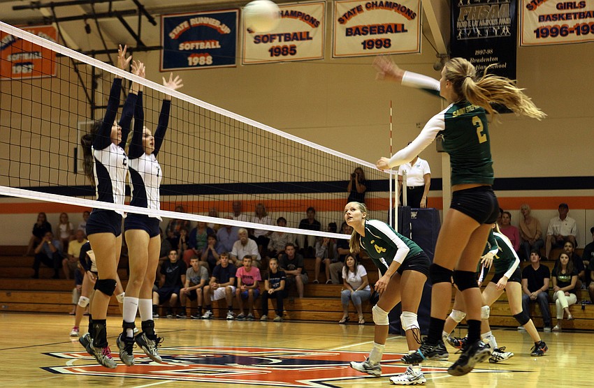 Melissa Johnson, No. 2, hits the ball over the net at Haley Preininger, No. 2, and Emily Greenwood, No. 7.
