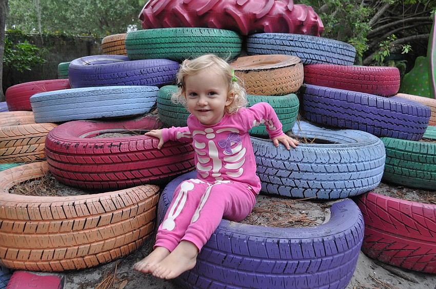Trinity Lemurian climbs on the gardenâ€™s tower of painted tires.