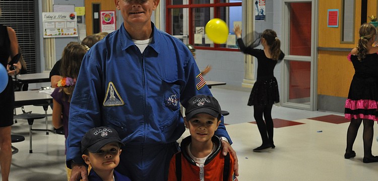 Gary Sandler and his sons Alex and Brandon dressed as astronots and played with balloons at the Freedom Elementary Character Dance.