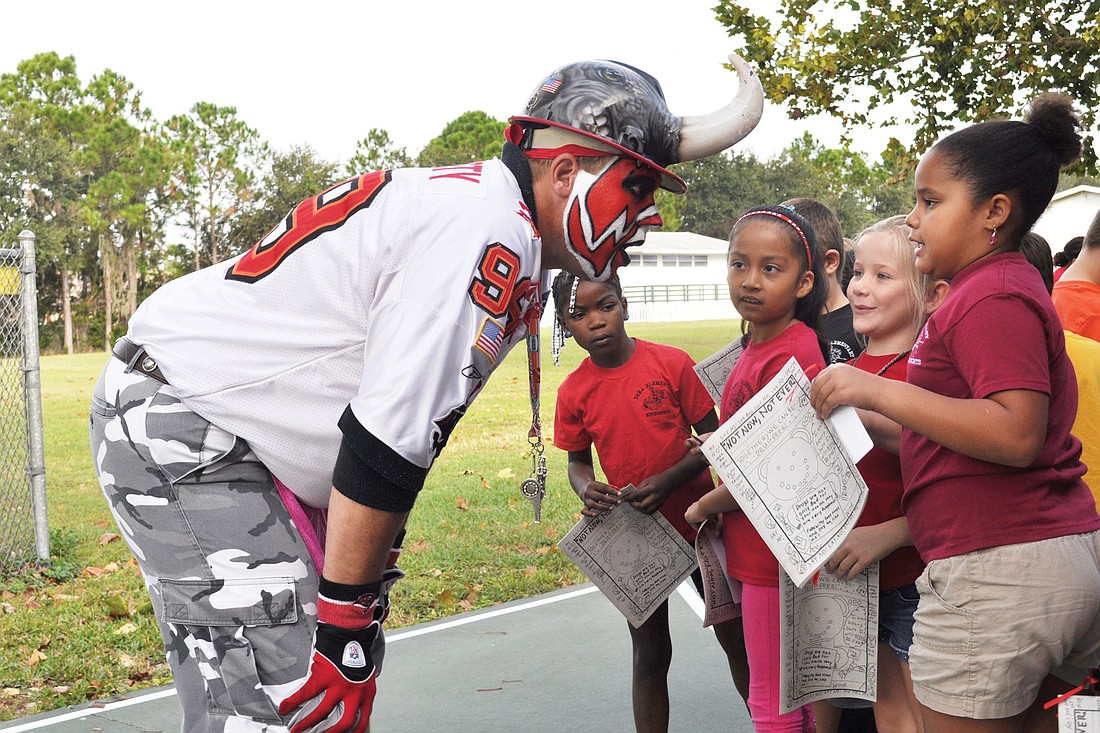 Before he warned students about the danger of drugs, Keith Kunzig, an NFL Hall of Fame member and crazed Tampa Bay Buccaneers fan, greeted kids individually.