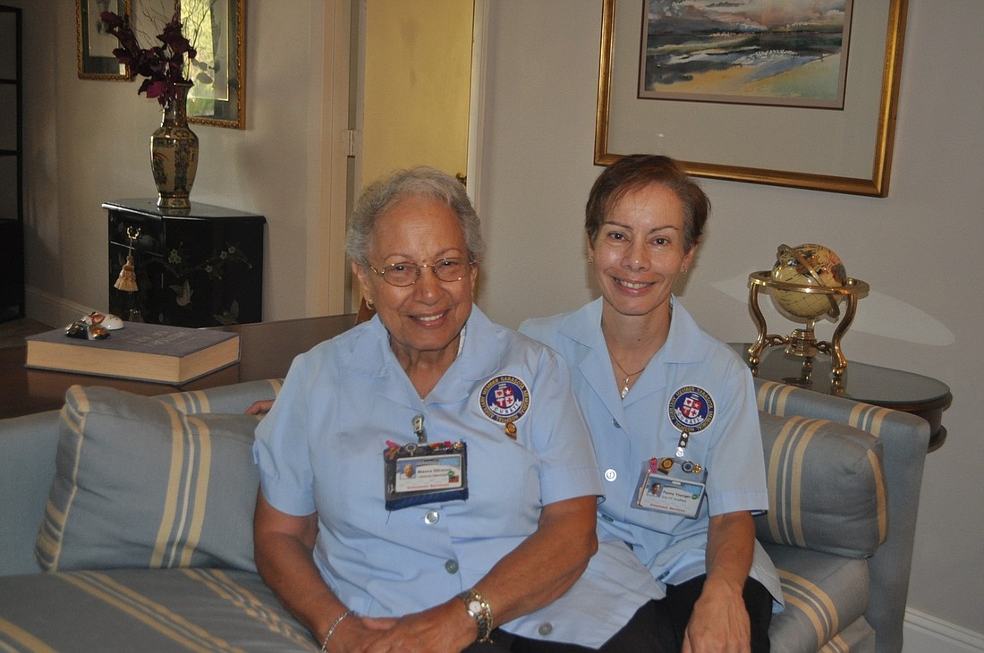 Blanca Di Cecco and her daughter, Fanny Younger, sport the smocks they wear while volunteering at Sarasota Memorial Hospital.
