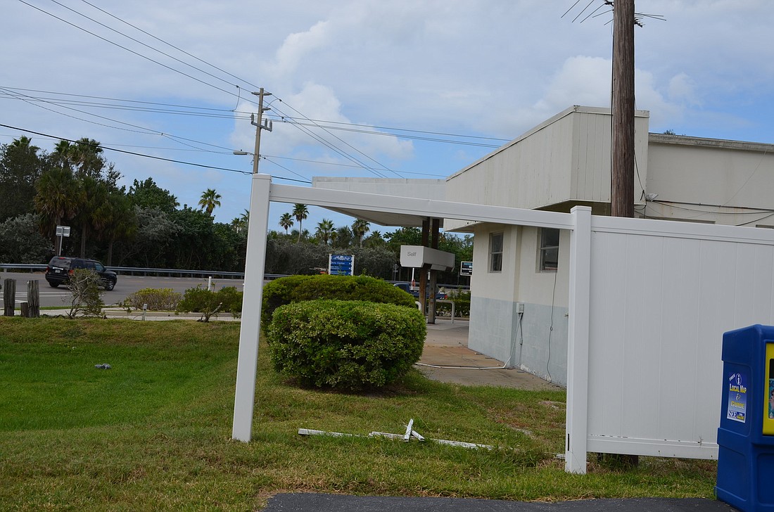 Town officials are concerned about a sinking hole in the post office building at Whitney Beach Plaza and a fence with panels falling down at the former gas station site.