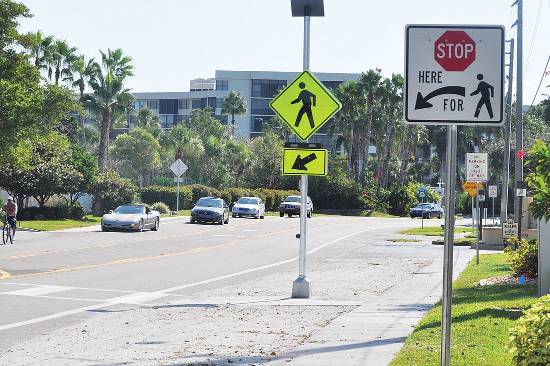 FDOT installed flashing pedestrian signs next to the Midnight Pass Road crosswalks and also installed a white sign with a stop sign on it warning drivers to stop when the crosswalks are activated.