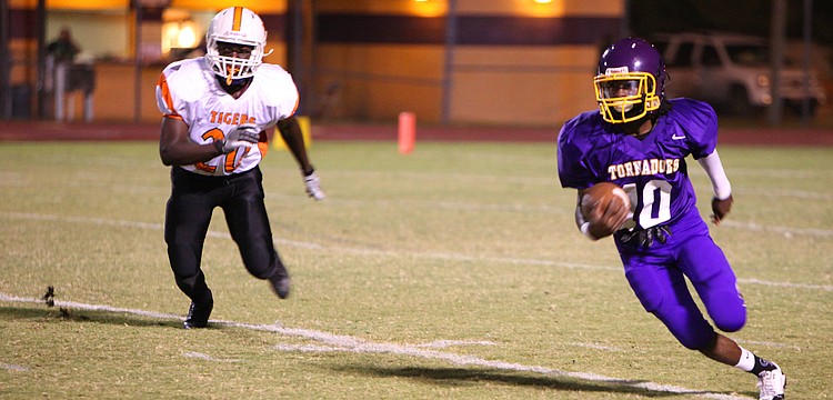 Brandon Brown, No. 10, runs with the ball while Dunbarâ€™s Gregory Houston, No. 20, tries to catch up to Brown.