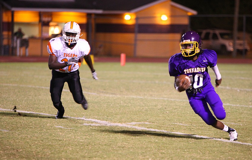 Brandon Brown, No. 10, runs with the ball while Dunbarâ€™s Gregory Houston, No. 20, tries to catch up to Brown.