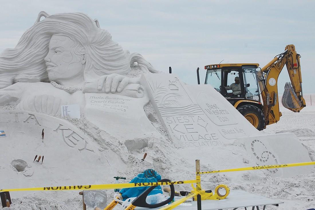 Sand sculptors begin crafting the sponsor scroll for the Siesta key Crystal Classic Master Sand Sculpting Competition.