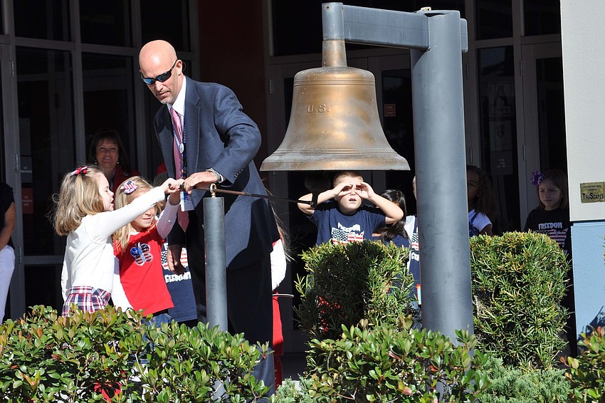 Principal Jim Mennes assisted students with ringing the Freedom Bell in the school courtyard at Freedom Elementary School.