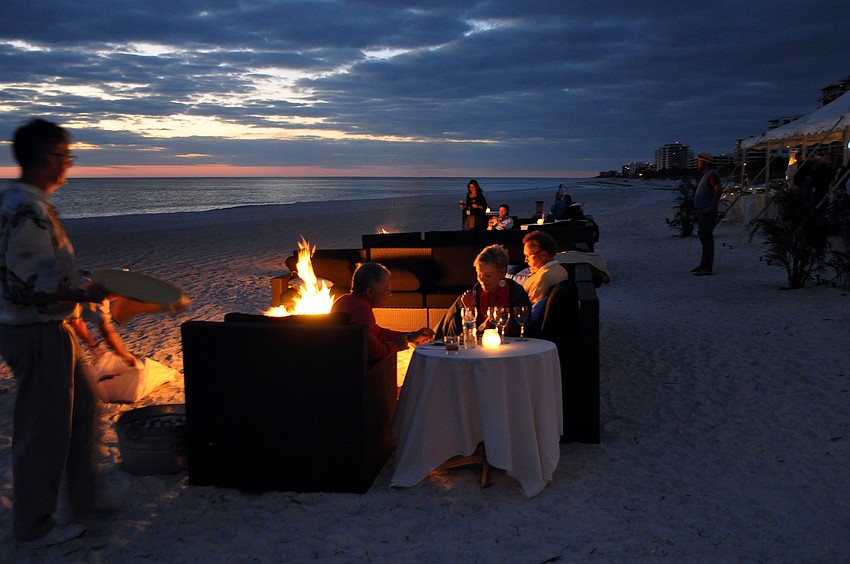 People enjoy wine and food on the beach while sitting by bonfires on couches Saturday, Nov. 10, during Bacchus on the Beach and the Longboat Key Club and Resort.