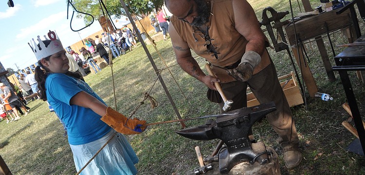 Abagael Burns waits for Blacksmith Pat DiPietro to make her a trinket.