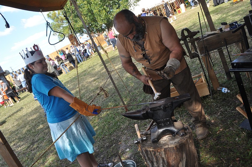 Abagael Burns waits for Blacksmith Pat DiPietro to make her a trinket.