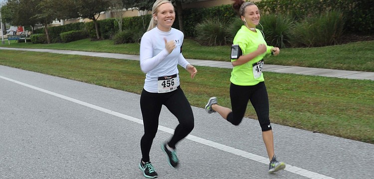 After going long on their warm-up, runners Stephanie Phillips and Avlan French set a quick pace to catch up with the group.