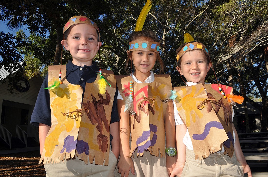 Jack Feeney, 5, Fiona Sutton, 6, and Ray Rini, 6, pose together to show off their Native American Indian outfits that they made for their Kindergarten Thanksgiving Program Monday, Nov. 19, at Out-of-Door Academy on Siesta Key.