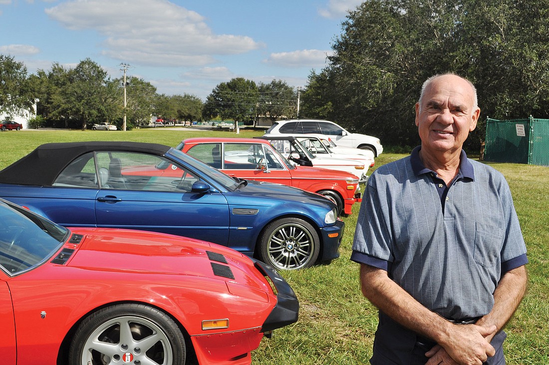 Peter Herke stands in front of his car collection, which includes several racing BMWs, a Porsche, a Pantera and his daily driver: a customized 1972 BMW 2002, dubbed "Shorty," whose back end he cut off.