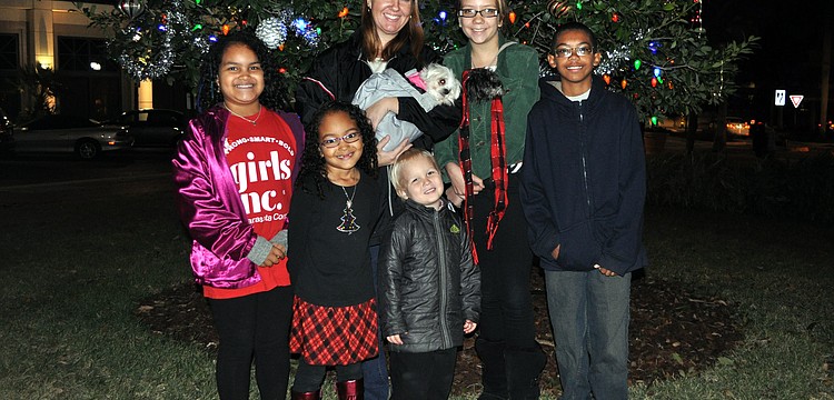 Rheanna Stephens, 8, Haela Stephens, 6, Laura Gilliam with Barbie, Rhett Gilliam, 3, Hannah Ward with Lucy, and Hunter Gilliam, 11, pose in front of the lit Christmas tree.