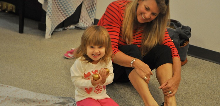 Darby Disalvo, 2, and her mother Courtney get ready to sing a song at storytime.