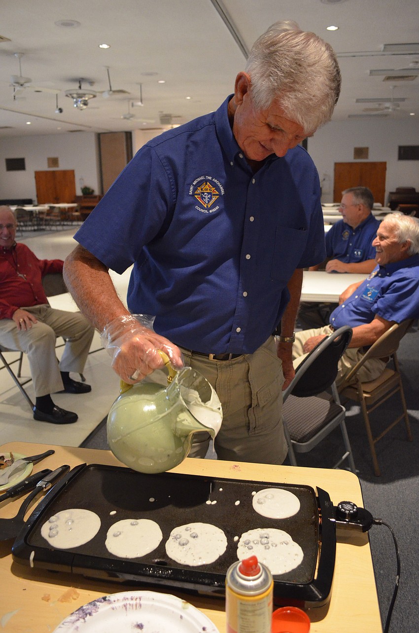 Jack Burnham makes blueberry pancakes for parish members.
