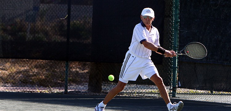 Ron Gatti goes across the court to hit a backhand shot during his singles match against Tim Fitzpatrick.