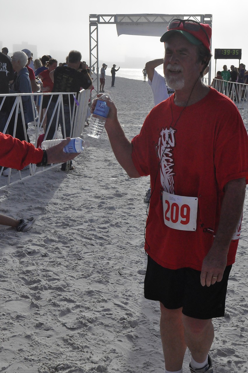 Larry Payne gets some water after his first 5K race.