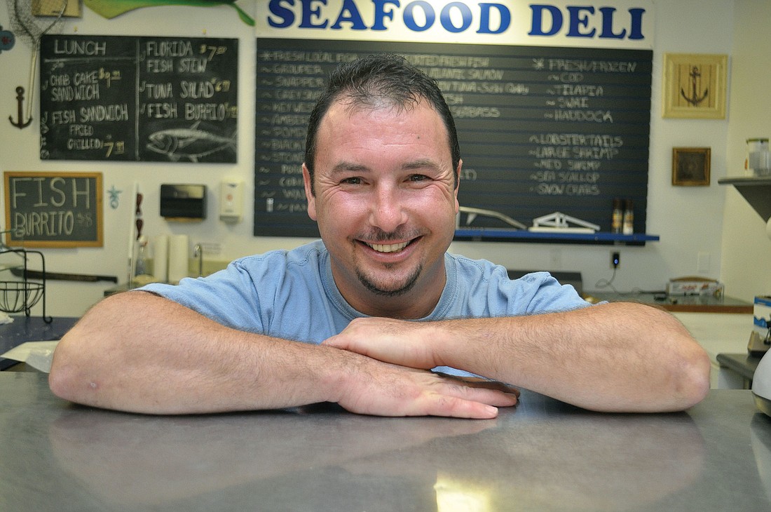 Scott Dolan, owner of Big Water Fish Market, stands behind the counter at his six-month-old store. During the recent tourist season, he shelled out 65 pounds of fish per day.
