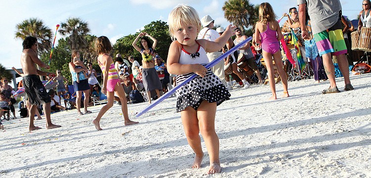 Zofia Cacko, 2 1/2, has fun with a hula-hoop, July 29, on Siesta Key Public Beach at the Drum Circle.