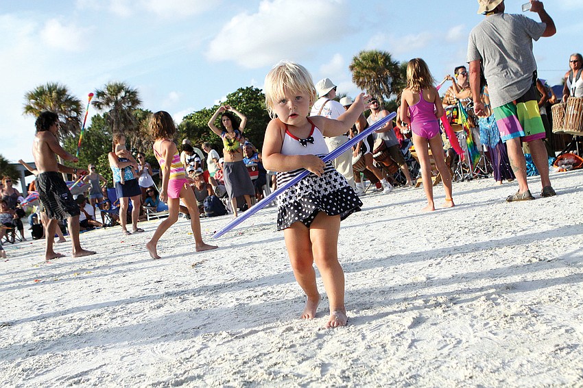 Zofia Cacko, 2 1/2, has fun with a hula-hoop, July 29, on Siesta Key Public Beach at the Drum Circle.