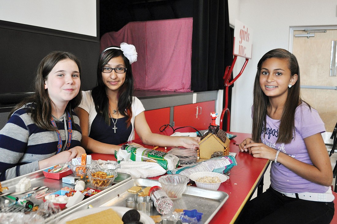 Payton Saturen, Alexandra Perez and Desiree Glasgow take a break from making their gingerbread house at Girls Inc.