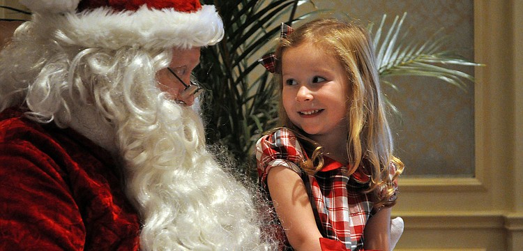 Norah Meyer, 3, smiles at Santa as he talks to her about what she might like for Christmas Sunday, Dec. 16, during the Breakfast with Santa event at the Ritz Carlton.
